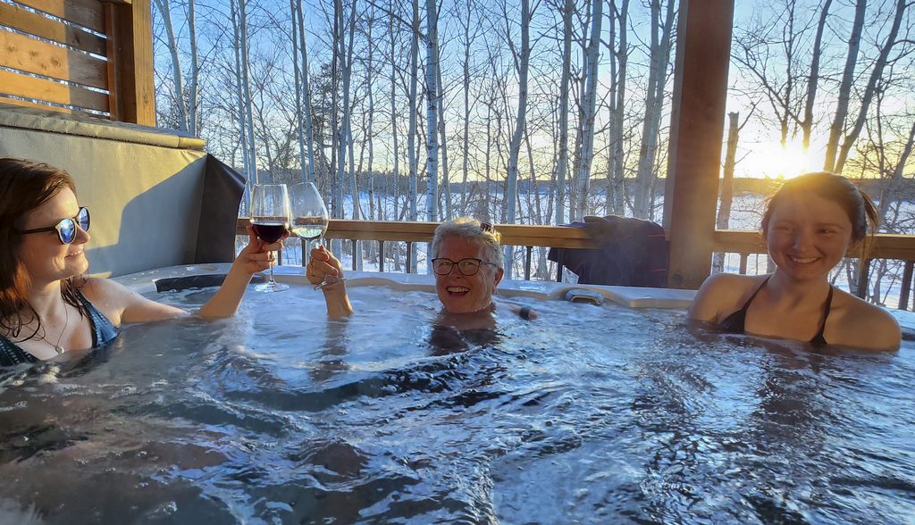 Guests enjoying the hot tub at Copper Shore Lake Houses in New Brunswick